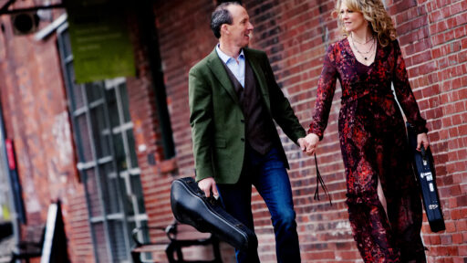 Canadian artists Natalie MacMaster & Donnell Leahy walking together, carrying instruments