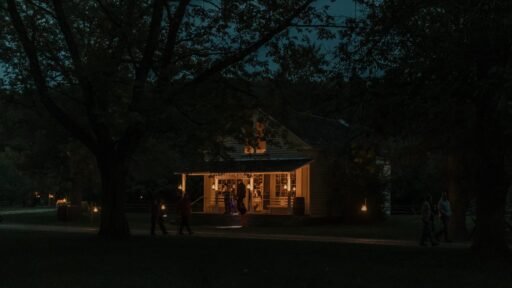 general store at night with lanterns lighting it up and people walking