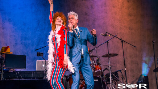 an image of 2 performers on stage singing and dancing