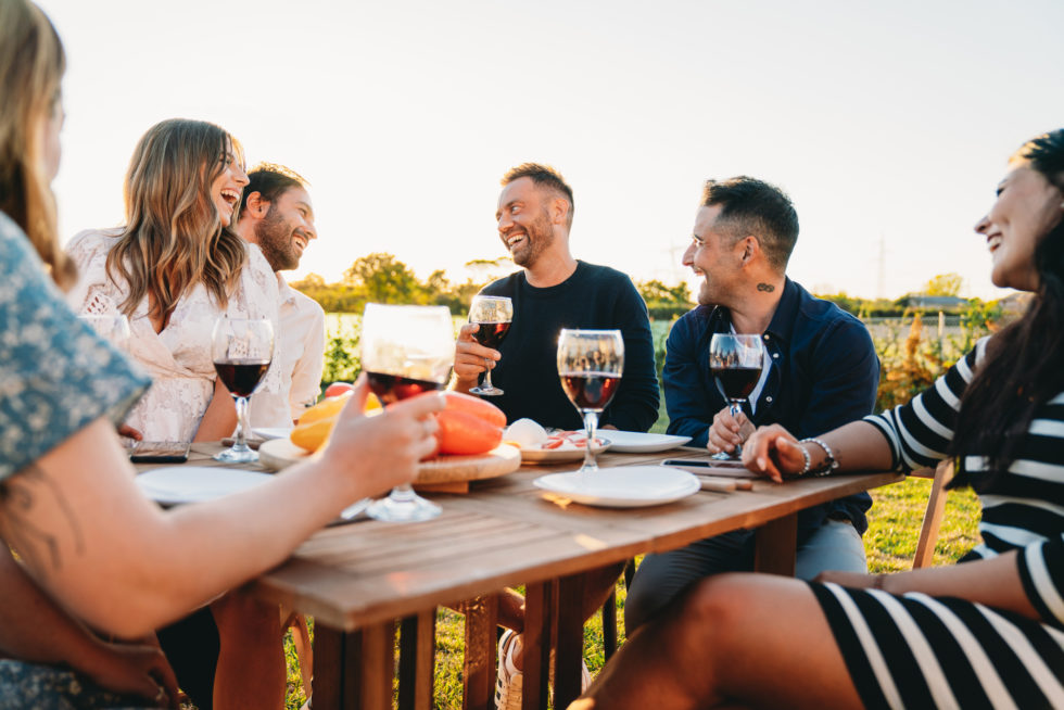 Group of people drinking wine around table
