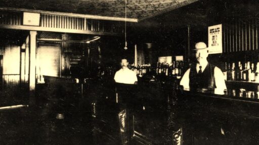an old image of two men standing at a bar