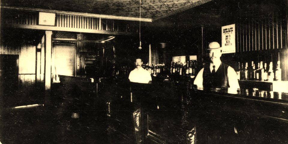 an old image of two men standing at a bar