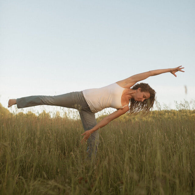woman doing yoga in a grass field