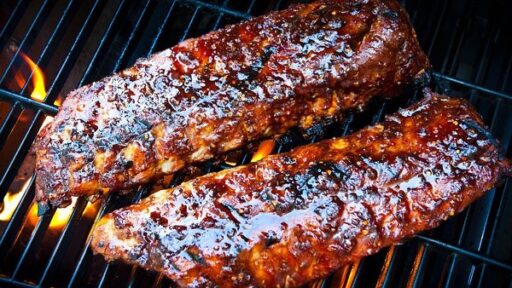 two racks of ribs on a grill