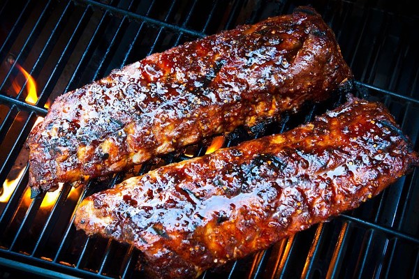 two racks of ribs on a grill