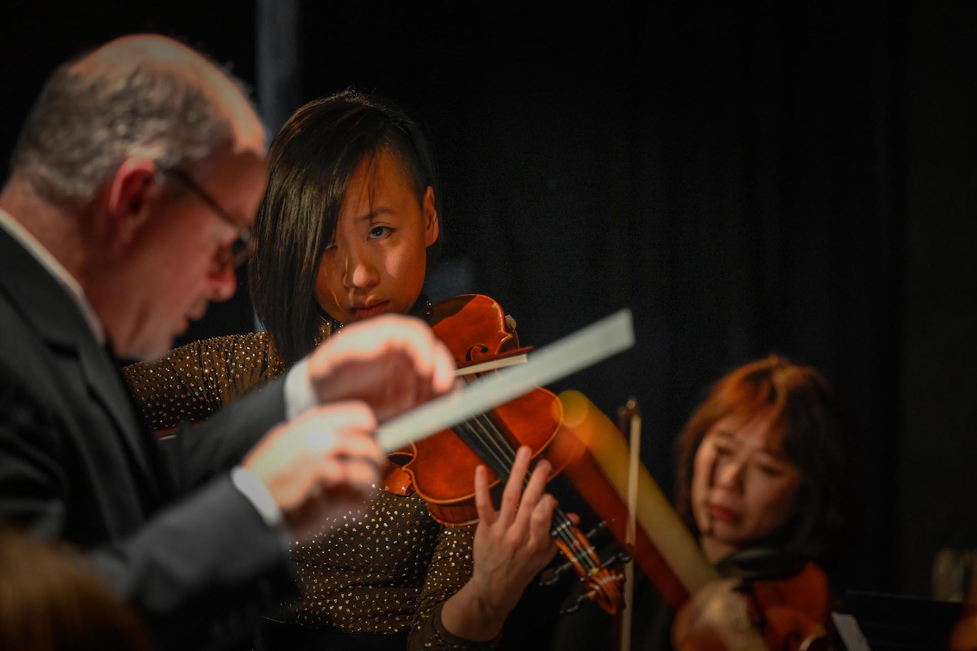 two woman playing the violin and a composer