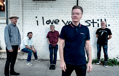 five men on a white brick wall