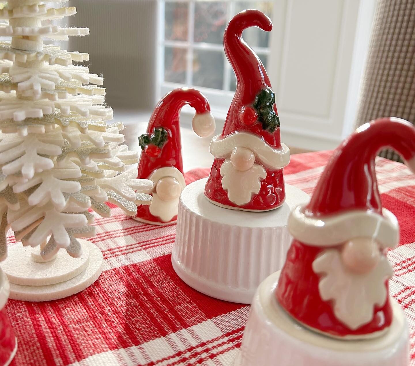 3 santa pottery and a mini white tree on a placemat