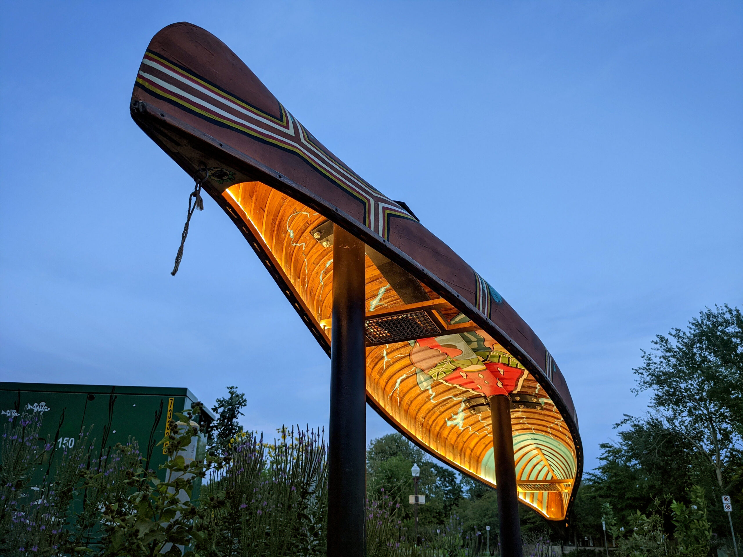 Public art display of a hand painted canoe illuminated from underneath