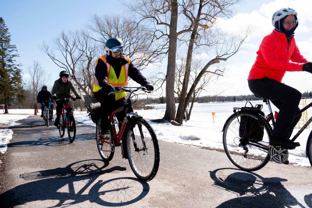 four people cycling on a path in the winter