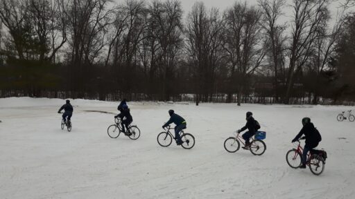 Five people cycling in snow