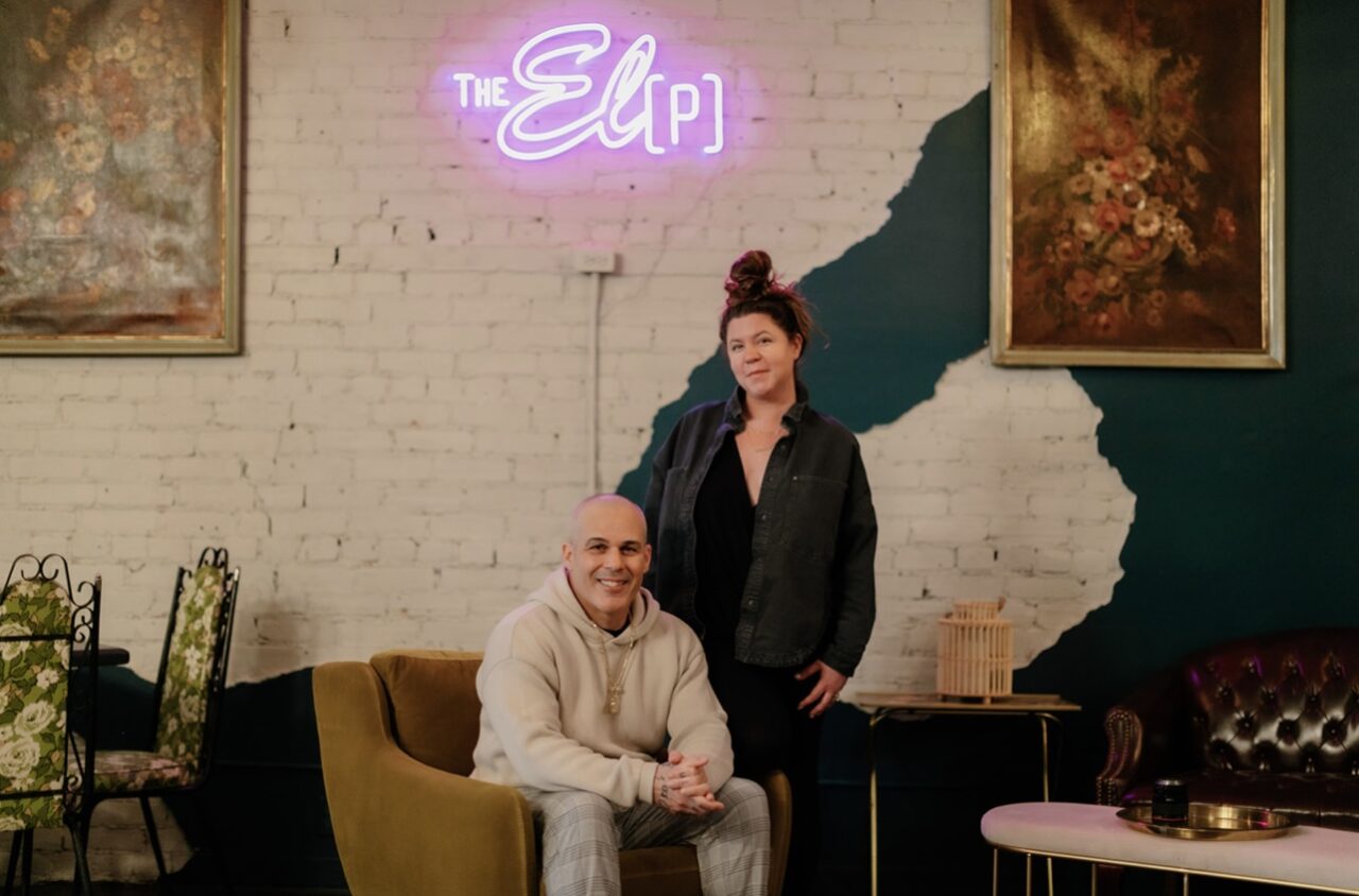 The El P owners Amanda and Greg Da Silva in the restaurant under a neon sign that says "The El [P]