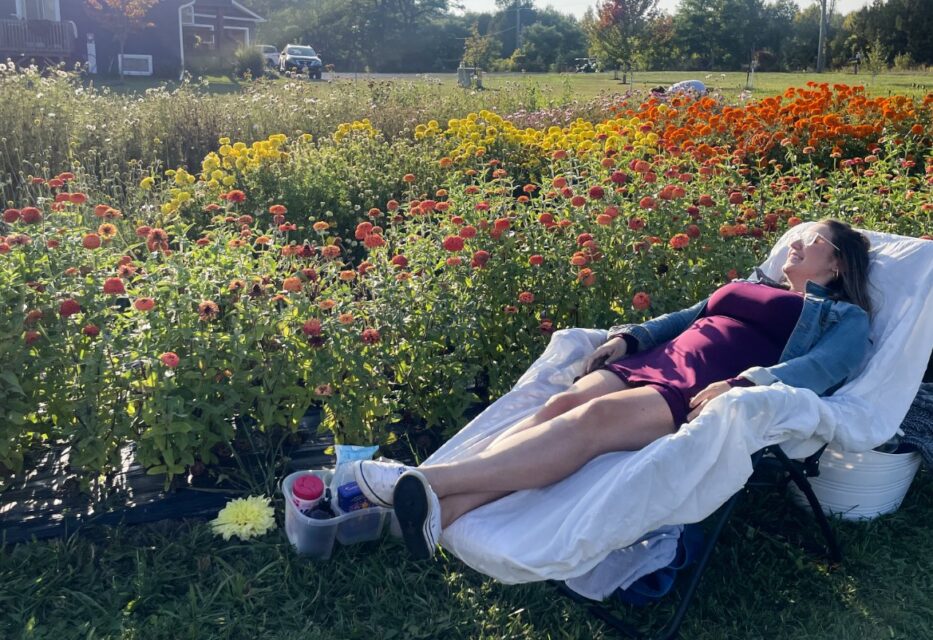 person laying on a chair in a flower field