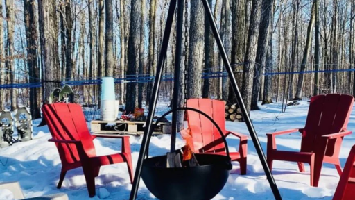 red chairs outside in snow in a circle with a fire in the middle