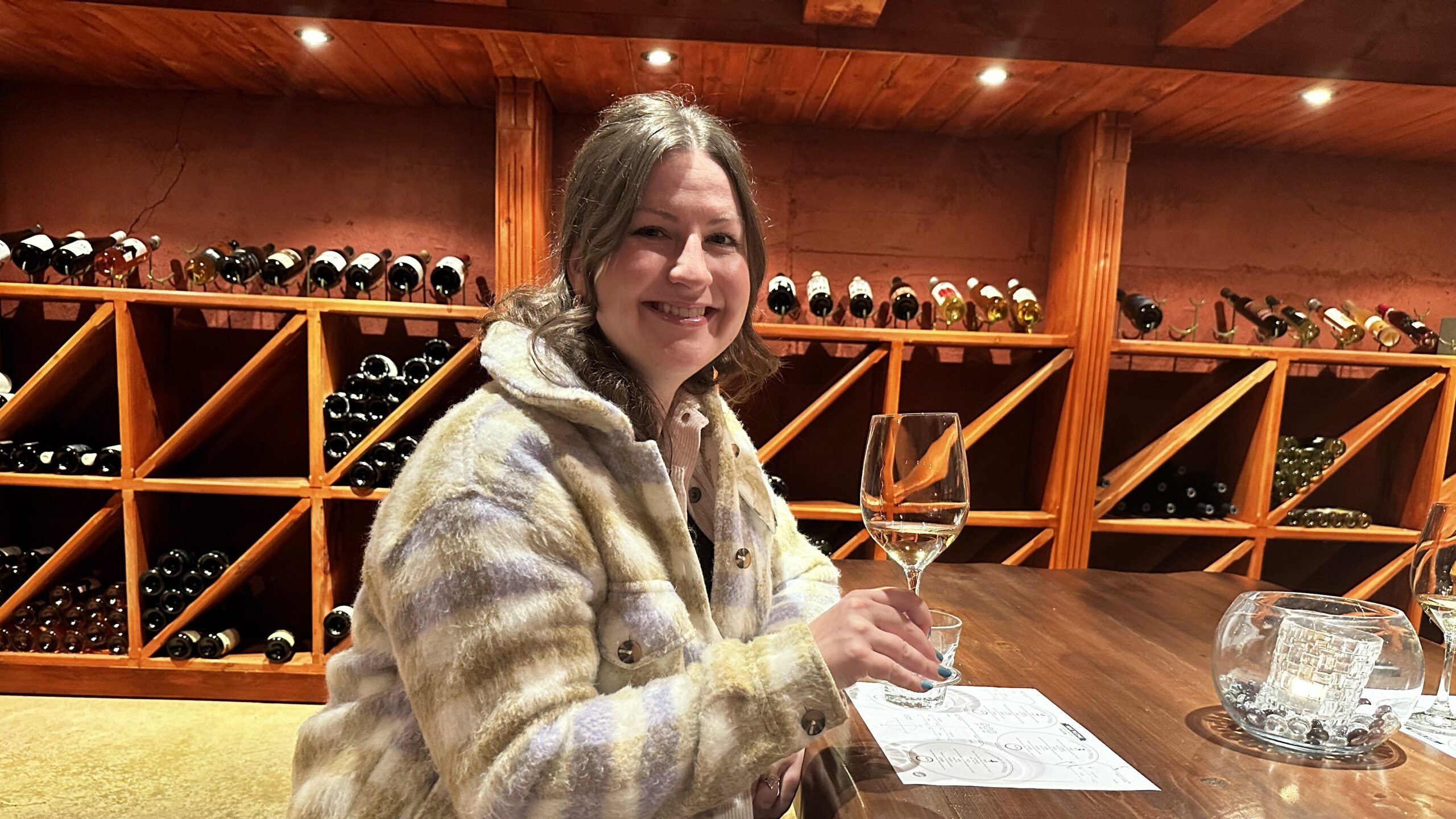 Bri Mitchell with wine glass in hand in the Wine Cellar at Elmhirst's Resort.