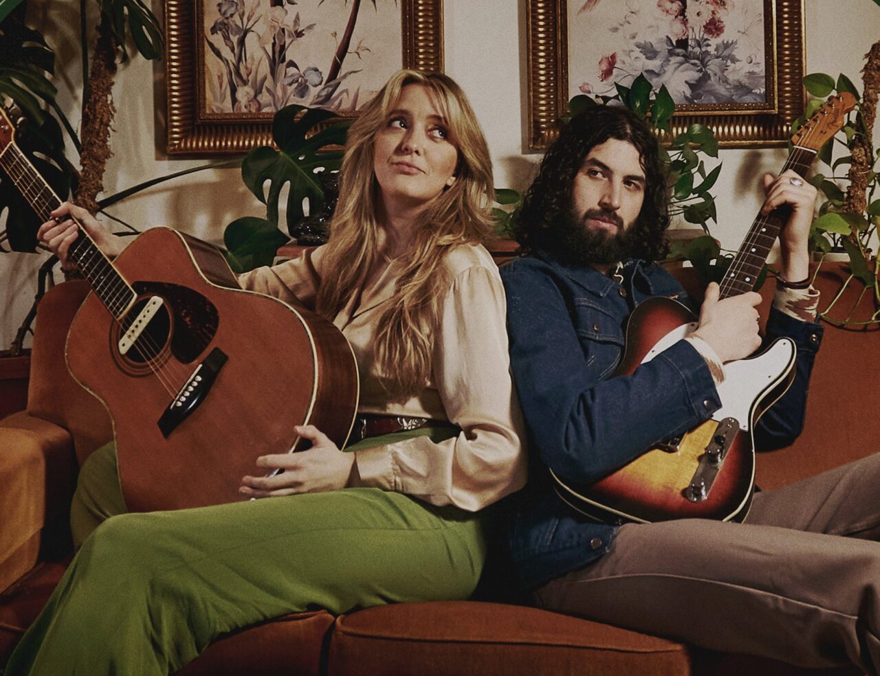 man and woman holding a guitar each