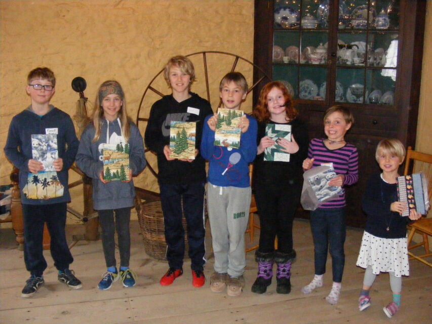 children holding their artwork