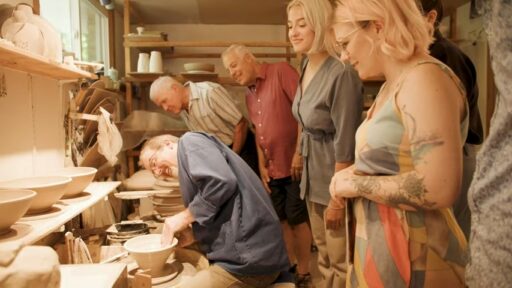 people watching a man do pottery